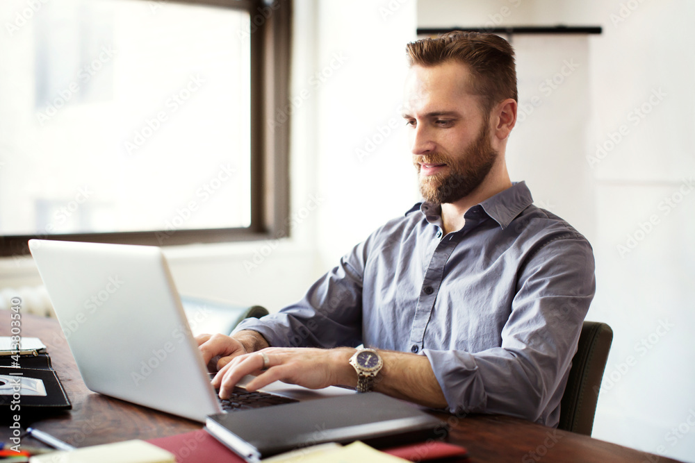 Businessman working on laptop computer in office Businessman working on laptop computer in office