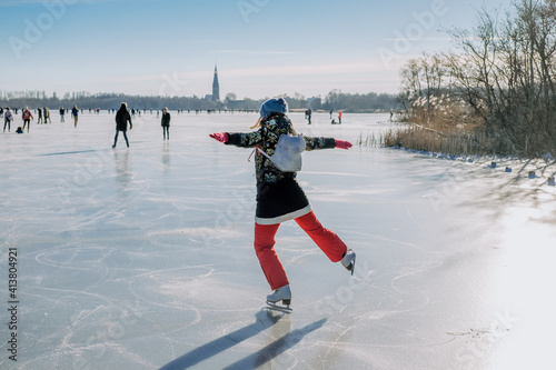 Woman skating on frozen winter lake in the Netherlands