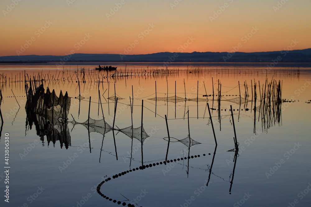 typical fishing system with rods and sticks, of the Valencia lagoon in Spain. sunset sky typical fishing system with rods and sticks, of the Valencia lagoon in Spain. sunset sky