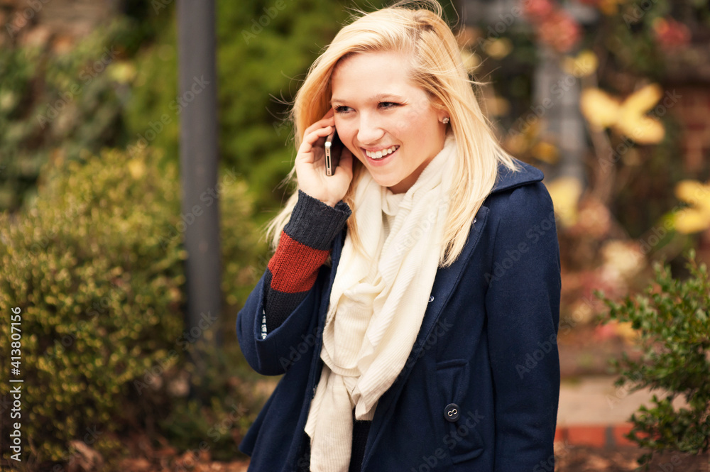 Cheerful woman talking on phone while standing at park during winter Cheerful woman talking on phone while standing at park during winter