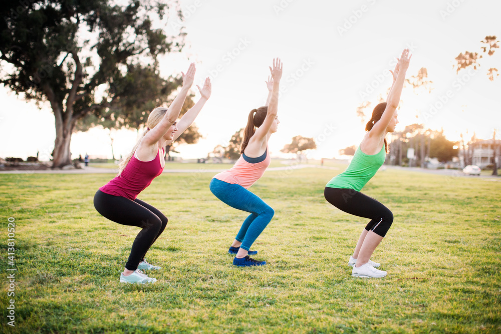 Friends exercising on grassy field on sunny day Friends exercising on grassy field on sunny day