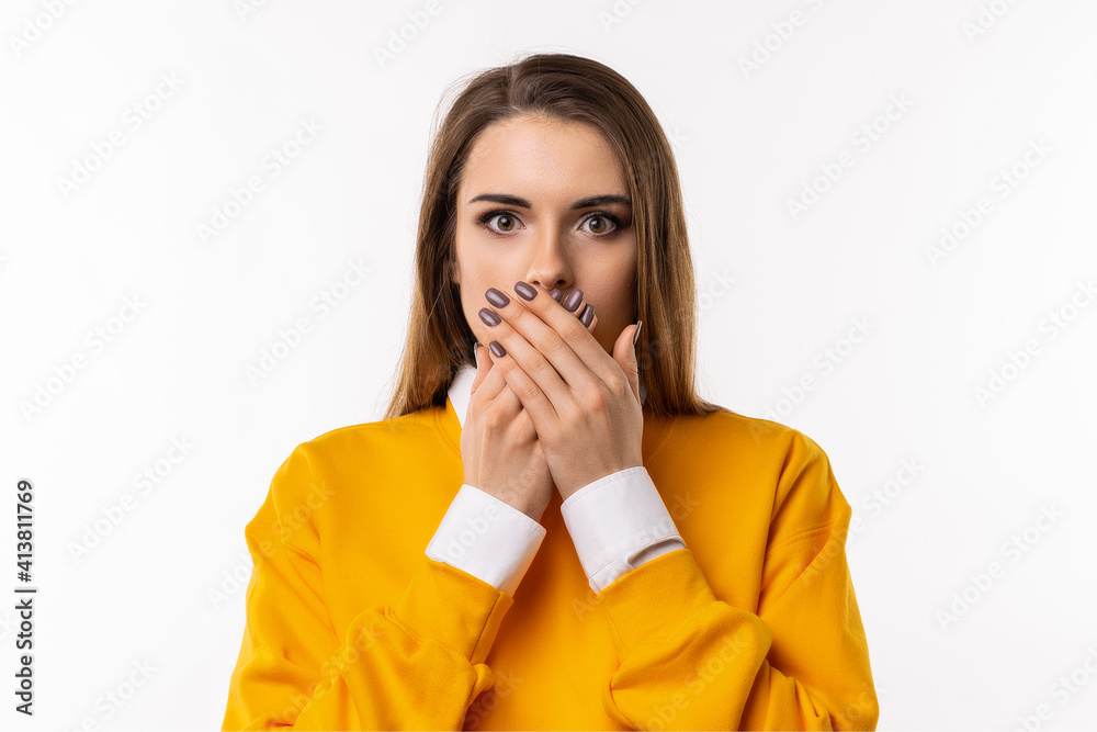 Frustrated brunette girlis covering mouth with two hands not willing to disclose something important. Keep a secret Frustrated brunette girlis covering mouth with two hands not willing to disclose something important. Keep a secret