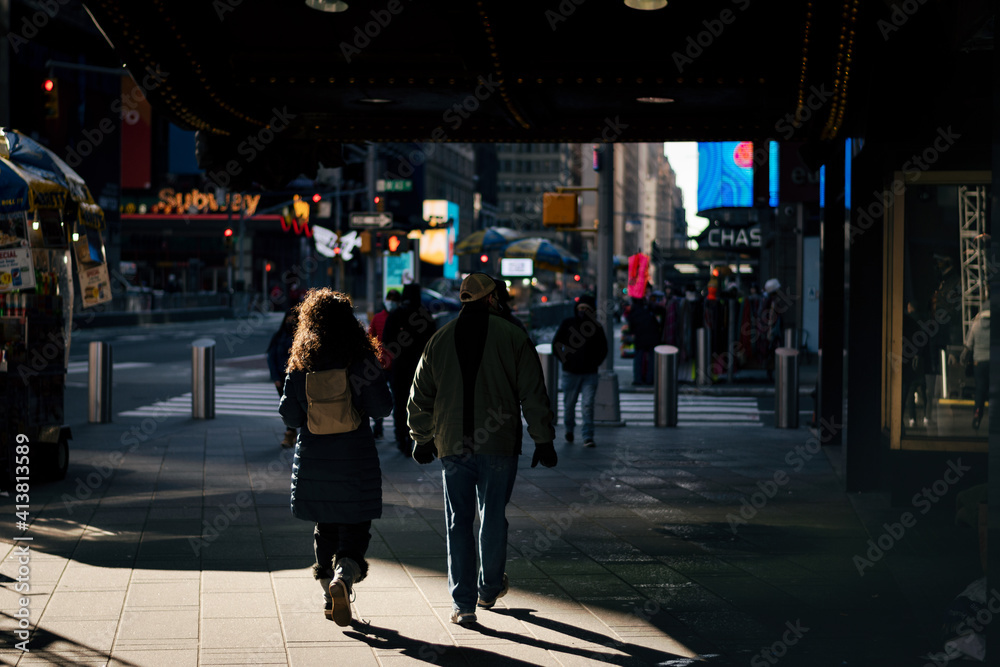 A Random couple walking down times sqaure in new york city exploring together. 
