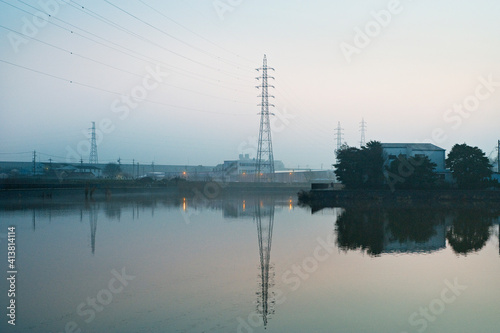 Electricity pylon by lake during sunset photo