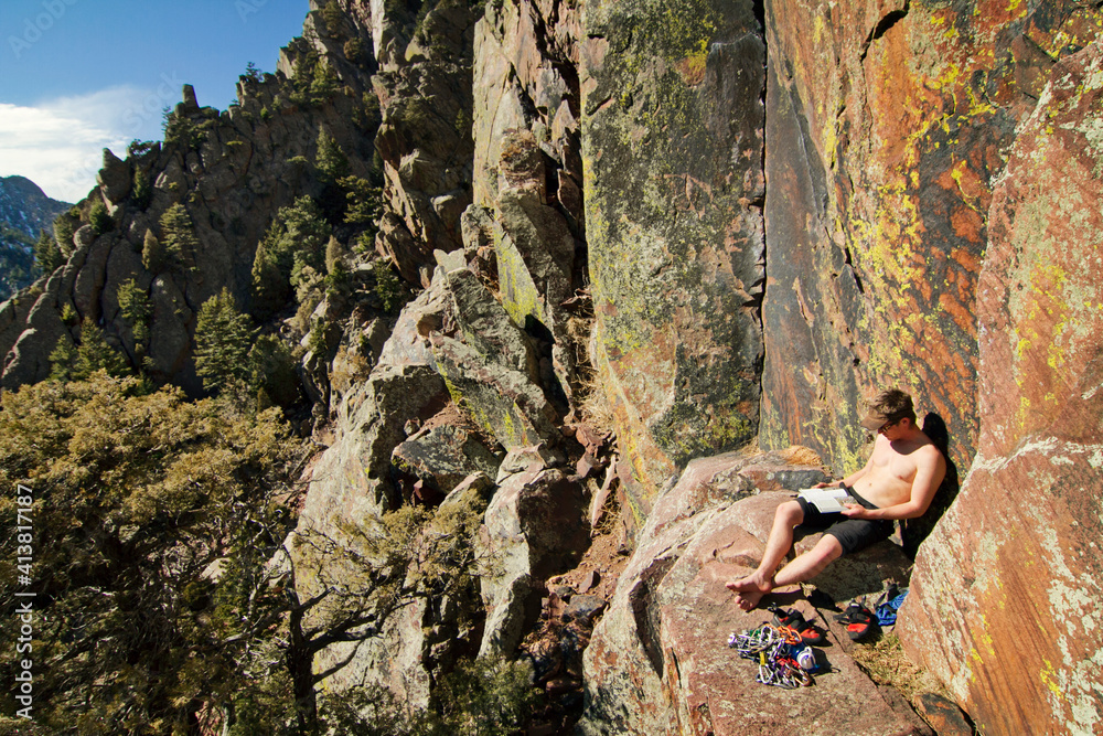 Climber reading book while sitting on mountain Climber reading book while sitting on mountain