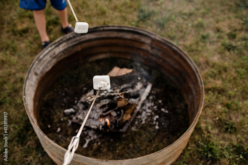 Wallpaper Mural Low section of boy roasting marshmallow in skewer over fire pit at backyard Torontodigital.ca