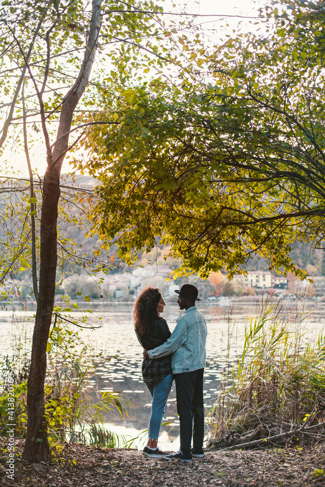 Side view of romantic couple standing at lakeshore Side view of romantic couple standing at lakeshore