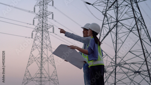 Two specialist electrical engineer working near to High voltage tower.