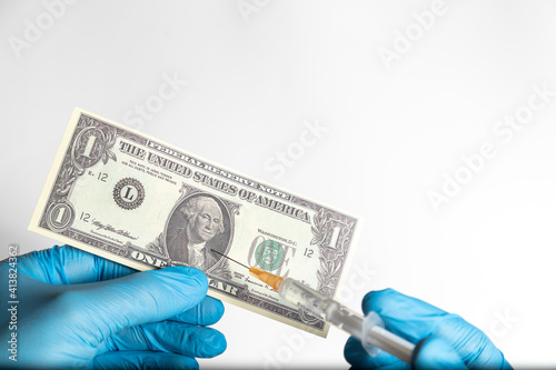 Vaccinating US one dollar (USD) - banknote held by protective gloves and syringe