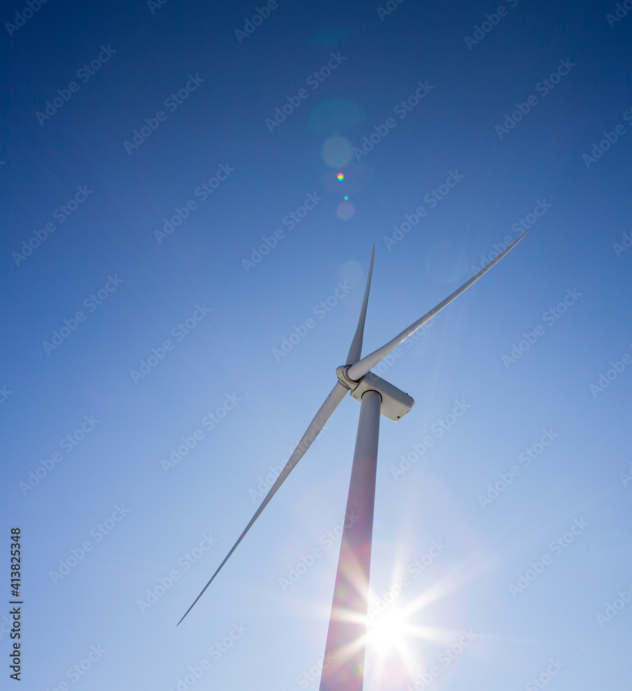 Wind turbines against blue sky with sun flare Wind turbines against blue sky with sun flare