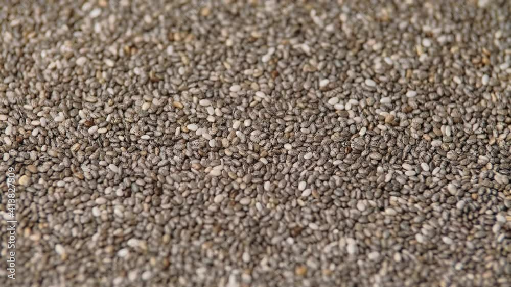 Chia seeds as a background food rotating with a warm llight Chia seeds as a background food rotating with a warm llight