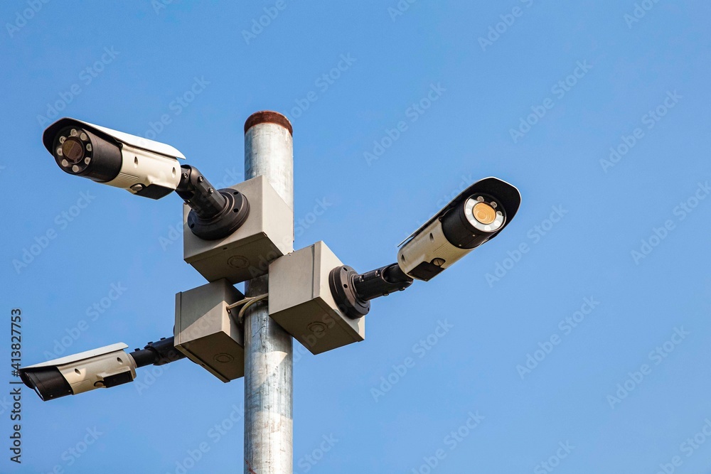 Three CCTV cameras on a tall pole at the park Three CCTV cameras on a tall pole at the park