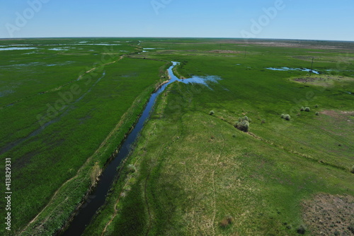 Zhambyl region, Kazakhstan - 05.17.2013 : An open valley with a riverbed and different vegetation for grazing animals photo