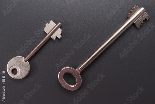 Ein kleiner und ein normalgroßer Tresorschlüssel, Safe-Schlüssel auf einem dunklen Hintergrund © lucky  photographer