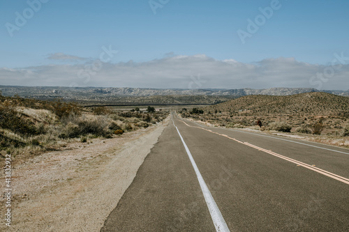 Lonely road with US Mexico border wall in distance near Jacumba, CA photo