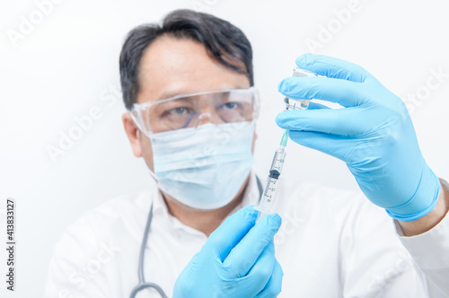 Young doctor wear blue gloves holding flu, measles, coronavirus, covid-19 vaccine