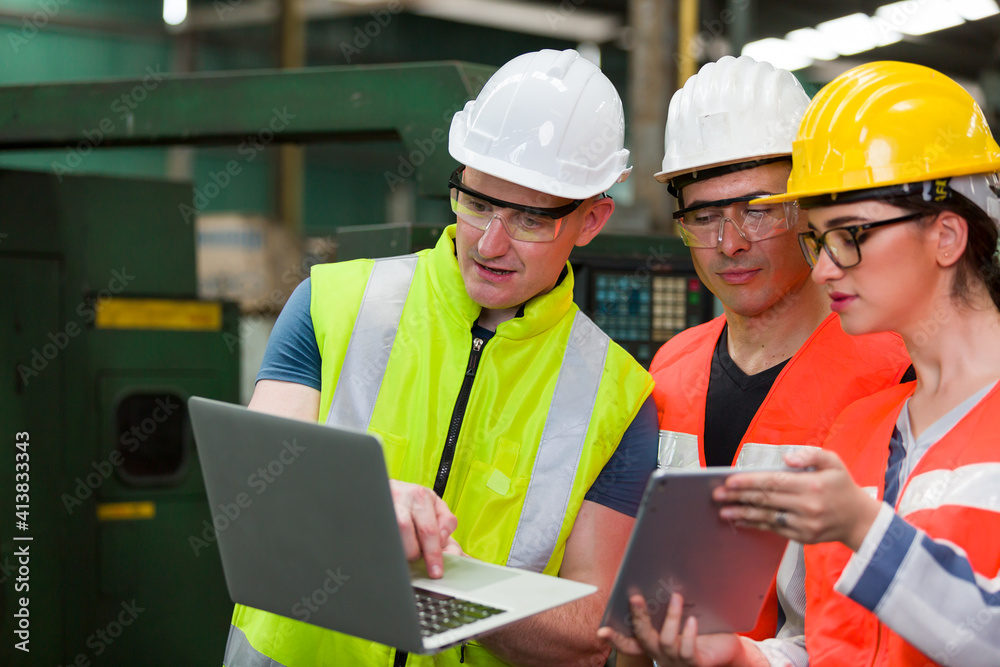 Diversity factory worker working with computer laptop in factory. Male and female worker wearing safety uniform, helmet and gloves at work factory. Group of worker working at factory Diversity factory worker working with computer laptop in factory. Male and female worker wearing safety uniform, helmet and gloves at work factory. Group of worker working at factory