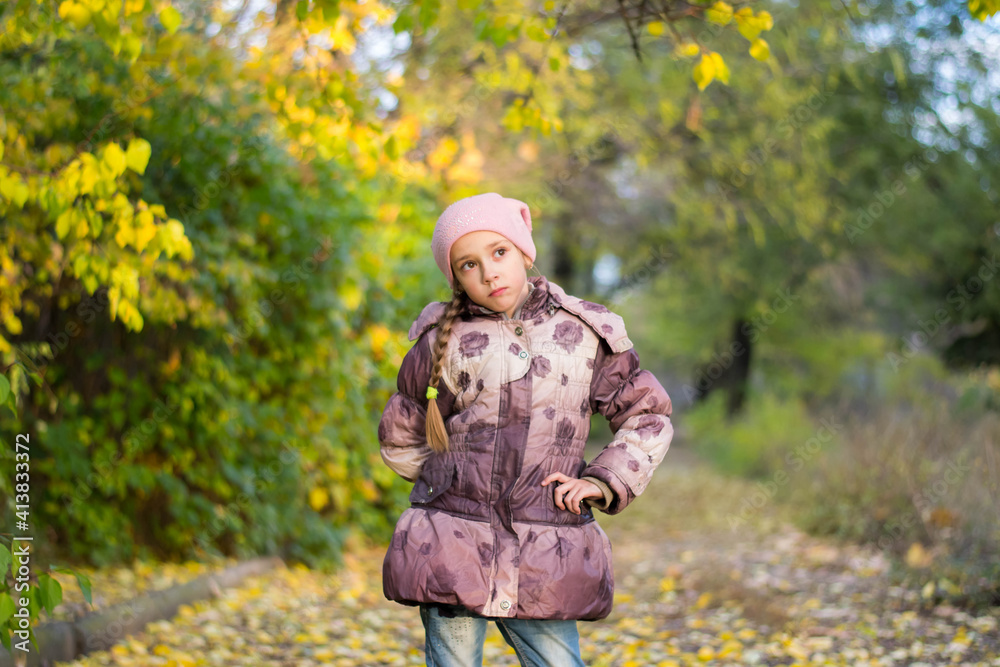A little girl in the park against the background of foliage and trees A little girl in the park against the background of foliage and trees