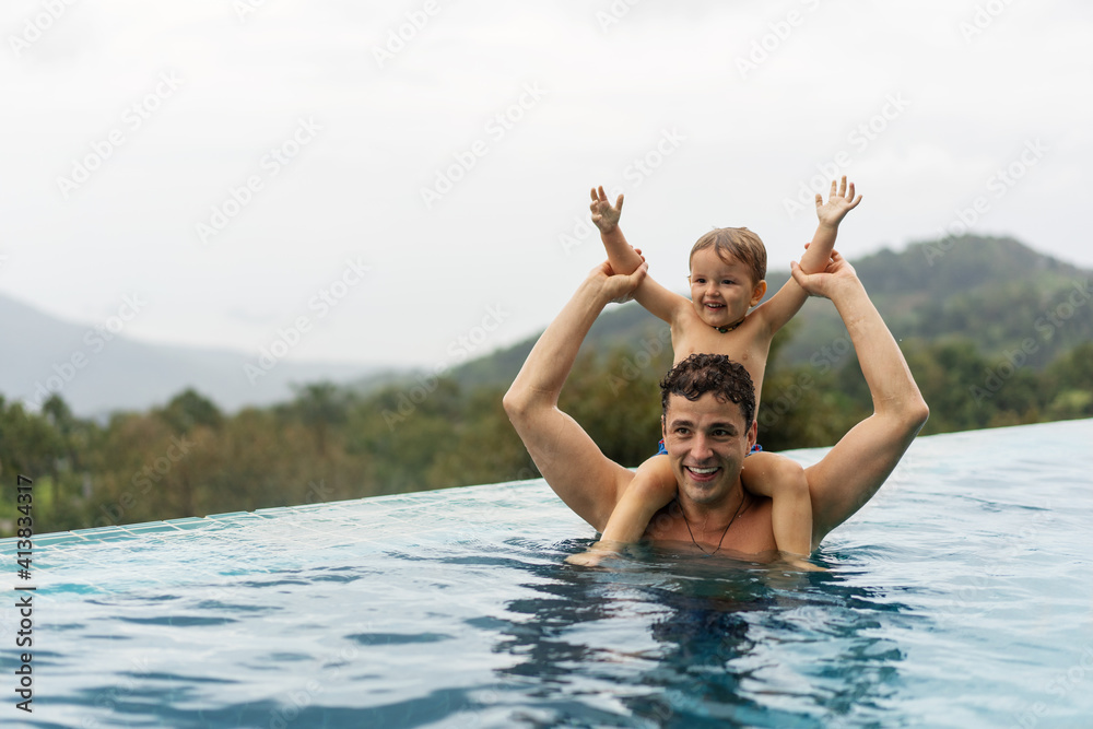 dad with his son in the pool against the background of mountains in Thailand dad with his son in the pool against the background of mountains in Thailand