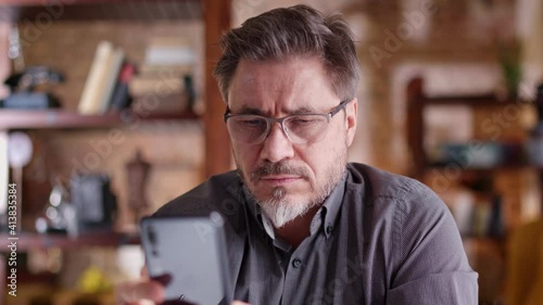 Man using phone at home. Working at home, chatting, posting or browsing the internet and social media.