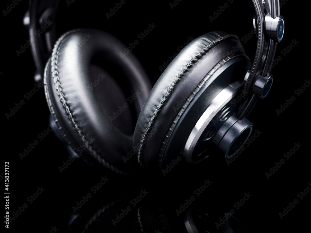 Black Hi-Fi headphones over a black reflective surface Black Hi-Fi headphones over a black reflective surface