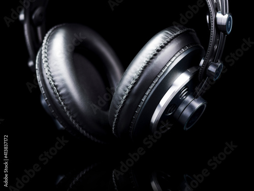 Black Hi-Fi headphones over a black reflective surface photo