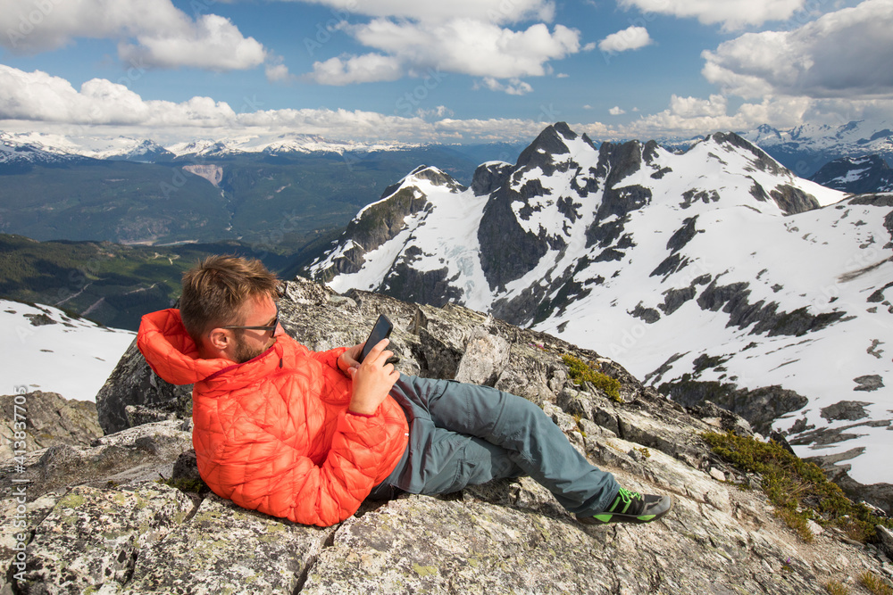 Climber sends a safety message from the summit of a mountain. Climber sends a safety message from the summit of a mountain.