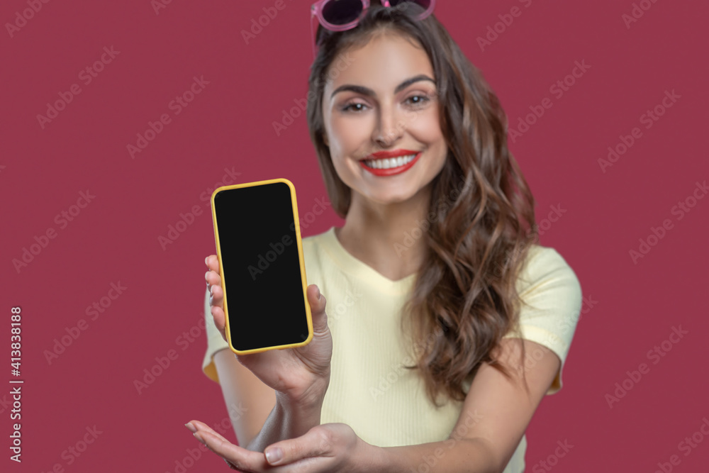 Beautiful young smiling woman showing smartphone screen Beautiful young smiling woman showing smartphone screen