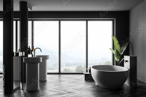 Two white sinks and bathtub in house on parquet floor near window