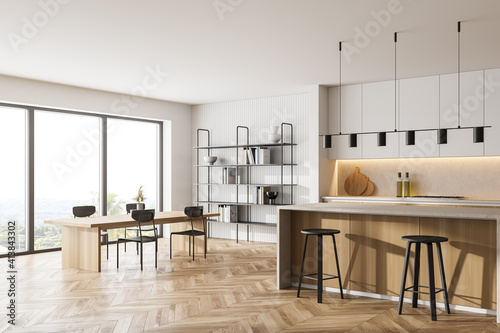 Wooden kitchen room with dining table and chairs, parquet floor photo