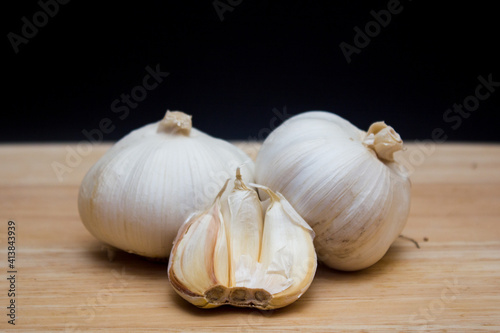 The garlics isolated black background on a wooden cutting board
