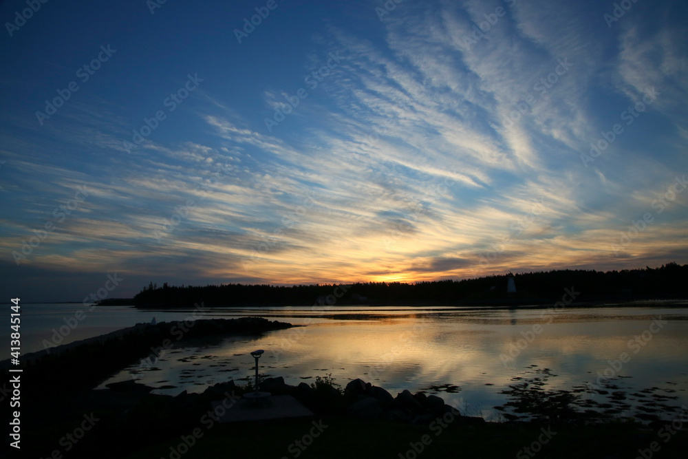 A summer sunrise along the coast of Maine showing white clouds and blu A summer sunrise along the coast of Maine showing white clouds and blu