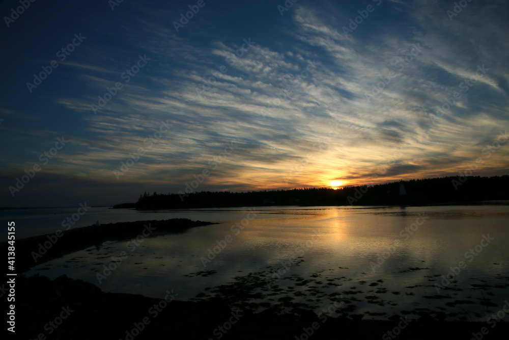 A summer sunrise along the coast of Maine showing white clouds and blu A summer sunrise along the coast of Maine showing white clouds and blu