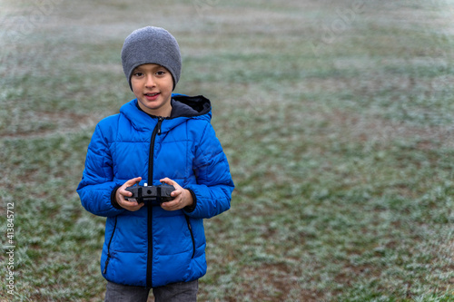 Boy playing with his remote-controlled helicopter in winter photo