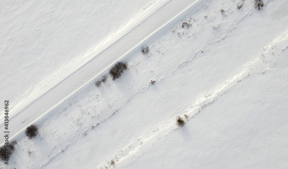 Obraz premium Top view of rural snowy road in winter