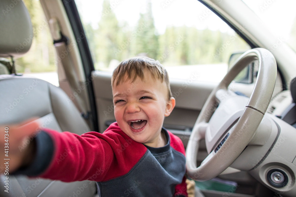 Happy little boy sitting on driver's seat in a car Happy little boy sitting on driver's seat in a car