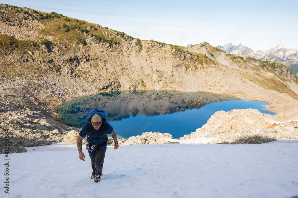 A solo mountaineer ascends a snow patch en to route Douglas Peak, B.C. A solo mountaineer ascends a snow patch en to route Douglas Peak, B.C.