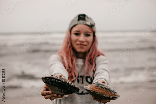 young woman holding shells on a beach photo