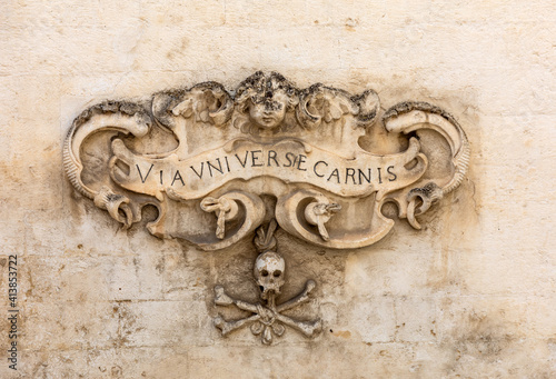 A bas-relief with a skull and a Latin inscription from the facade of the Church of Purgatorio in Gravina in Puglia. Italy