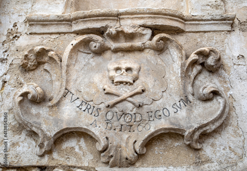 A bas-relief with a skull and a Latin inscription from the facade of the Church of Purgatorio in Gravina in Puglia. Italy