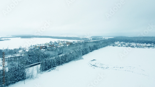 Aerial view from drone on blue snowy suburb in winter © Payllik