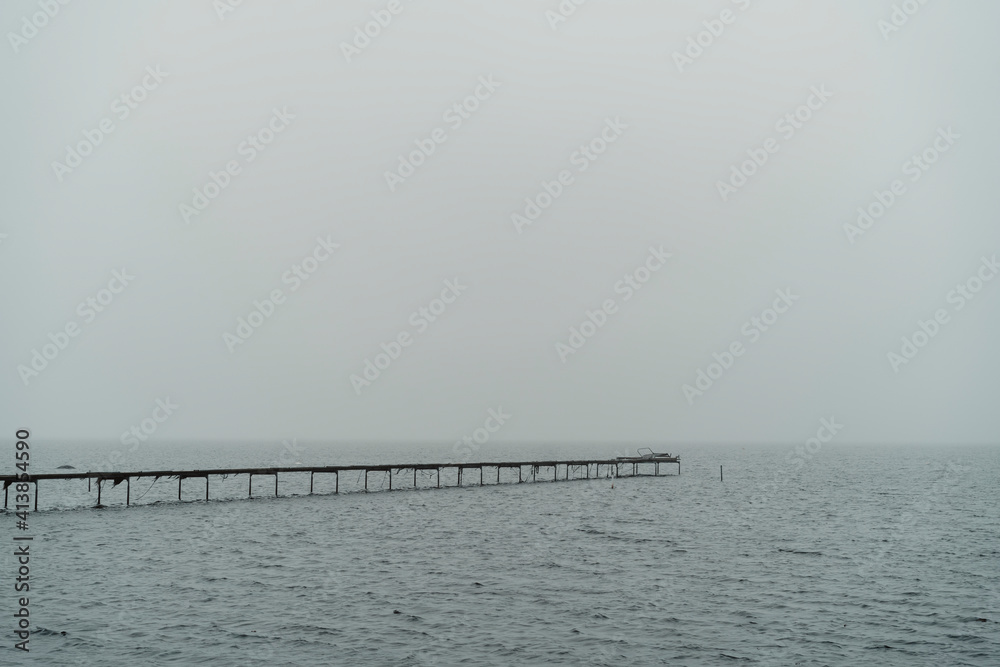 Wooden dock on cloudy day with on calm sea Wooden dock on cloudy day with on calm sea