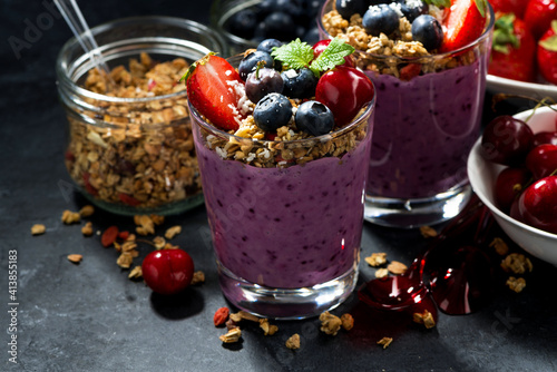 healthy dessert with fresh berries and granola on a dark background