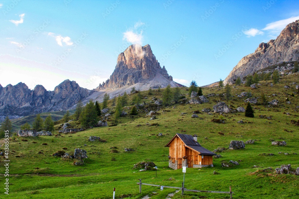 Refuge at the Sella Pass, blue sky, hut in the foreground, panoramic scene