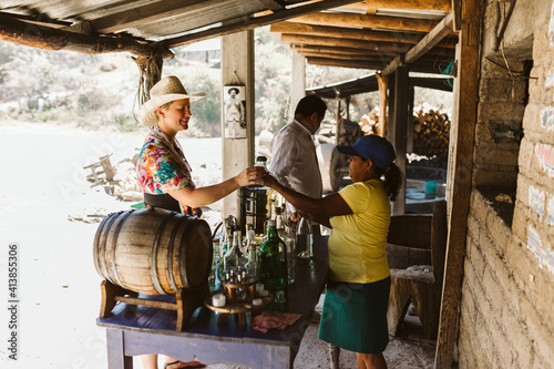 tourist tastes mezcal at a roadside distillery in oaxaca mexico photo