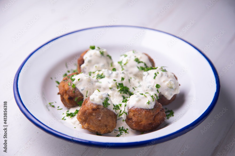 Greek meatballs with tzatziki cooked in a restaurant.