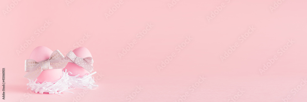Sweet easter banner with pink easter eggs with silver bow in white nest on pastel pink background