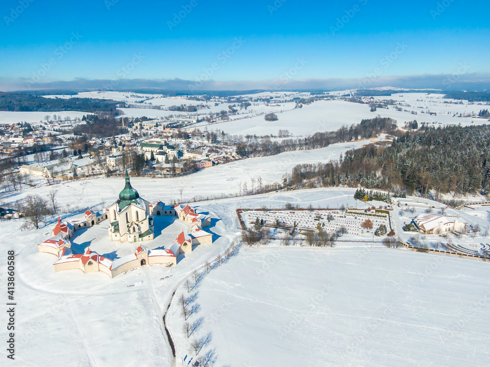 Aerial drone view of Pilgrimage Church of Saint John of Nepomuk, Zdar nad Sazavou, Czech Republic. UNESCO heritage. Ancient monastery at Zelena Hora hill. Winter weather with snow, blue sky.