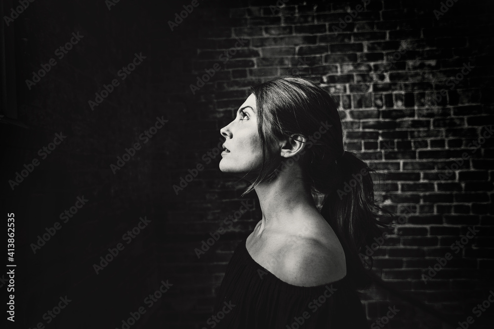Young woman in profile with shoulders showing looking up at the light Young woman in profile with shoulders showing looking up at the light