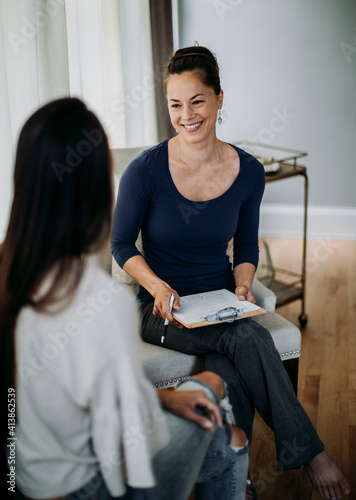 A massage therapist laughs as she gets to know her client